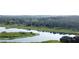 A scenic view of a tranquil lake surrounded by lush trees and vegetation, offering a serene and natural setting at 10809 Arrowtree Blvd, Clermont, FL 34715