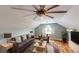 Cozy living room offering plenty of natural light, hardwood floors, and a ceiling fan for added comfort at 10809 Arrowtree Blvd, Clermont, FL 34715
