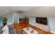 This light and airy living room features hardwood floors, a wet bar, and large TV for relaxation and entertainment at 10809 Arrowtree Blvd, Clermont, FL 34715