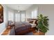 Comfortable and cozy main bedroom with a bay window, plantation shutters, and hardwood floors at 10809 Arrowtree Blvd, Clermont, FL 34715