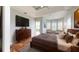 This luxurious main bedroom offers hardwood floors, tray ceiling, private balcony, and plantation shutters at 10809 Arrowtree Blvd, Clermont, FL 34715