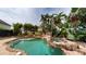 Tropical pool area with rock features, lush landscaping, and a soothing waterfall creating a private oasis at 10809 Arrowtree Blvd, Clermont, FL 34715