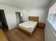 Bright bedroom with light wood floors, natural light, closet, and side table at 118 S Halifax Ave # 409, Daytona Beach, FL 32118
