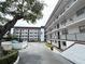 Well-maintained condo building featuring multiple levels and private balconies, surrounded by lush landscaping and mature trees at 118 S Halifax Ave # 409, Daytona Beach, FL 32118