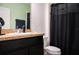 Bathroom features a single sink vanity and a shower/tub combination with black shower curtain at 130 Claire Ln, Davenport, FL 33837