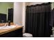 This bathroom includes a shower/tub, toilet and single sink vanity with a dark cabinet at 130 Claire Ln, Davenport, FL 33837