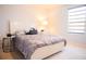 Cozy bedroom with a white bed frame, decorative pillows, and a window with a zebra shade at 130 Claire Ln, Davenport, FL 33837