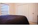 Bedroom featuring a queen-size bed, white closet doors, and a modern window shade at 130 Claire Ln, Davenport, FL 33837