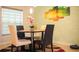 The dining area features a round table with four chairs, a floral centerpiece, and a window with blinds at 130 Claire Ln, Davenport, FL 33837