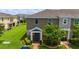 Charming two-story townhome featuring a blue front door, lush green lawn, and brick walkway at 130 Claire Ln, Davenport, FL 33837