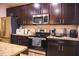 Well-equipped kitchen boasts stainless steel appliances, dark cabinetry, and granite countertops at 130 Claire Ln, Davenport, FL 33837