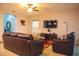 Comfortable living room features a plush leather sofa, a TV, and a colorful area rug at 130 Claire Ln, Davenport, FL 33837