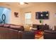 Comfortable living room features a plush leather sofa, a TV, and a colorful area rug at 130 Claire Ln, Davenport, FL 33837