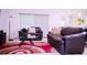 Open living room featuring brown leather sofas, a glass coffee table, and a red patterned rug at 130 Claire Ln, Davenport, FL 33837
