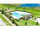Aerial view of the community pool with palm trees, lounge chairs, and a clubhouse at 130 Claire Ln, Davenport, FL 33837