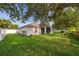 Landscaped backyard featuring green grass, lush trees, and a white fence at 1415 Ellis Fallon Loop, Oviedo, FL 32765