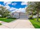Well-maintained gray home with a spacious driveway, two-car garage, and manicured lawn at 1415 Ellis Fallon Loop, Oviedo, FL 32765