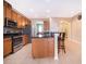 Kitchen with stainless appliances, wood cabinets, and granite countertops with a breakfast bar at 1415 Ellis Fallon Loop, Oviedo, FL 32765