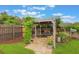 Charming backyard featuring a pergola with seating, lush greenery, and a peaceful garden setting at 142 Florence Blvd, Debary, FL 32713