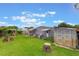 Spacious backyard featuring a well-manicured lawn, garden area, storage shed, and seating, perfect for relaxation at 142 Florence Blvd, Debary, FL 32713
