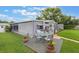 Lush backyard with a wooden deck, outdoor dining set, and well-maintained lawn, perfect for entertaining at 142 Florence Blvd, Debary, FL 32713