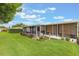 Serene backyard featuring a spacious screened-in patio, lush greenery, and well-maintained lawn at 142 Florence Blvd, Debary, FL 32713