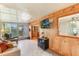 Cozy living room featuring wood paneled walls, tiled floors, and a comfortable couch with natural light at 142 Florence Blvd, Debary, FL 32713