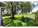 Spacious backyard with lush greenery, a pond view, and a fenced perimeter at 14224 Colonial Lakes Dr, Orlando, FL 32826
