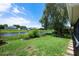 Lush green backyard with a pond view and mature trees, perfect for outdoor enjoyment at 14224 Colonial Lakes Dr, Orlando, FL 32826