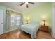 Comfortable bedroom featuring wood floors, two bedside tables, and a large window, creating a relaxing space at 14224 Colonial Lakes Dr, Orlando, FL 32826