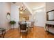 Bright dining area featuring wood floors, chandelier lighting, and seamless access to the kitchen and front entrance at 14224 Colonial Lakes Dr, Orlando, FL 32826