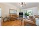 Cozy living room with hardwood floors, a comfortable sofa, and sliding glass doors opening to the outdoor patio at 14224 Colonial Lakes Dr, Orlando, FL 32826
