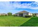 Spacious backyard with well-kept lawn and rear view of house is perfect for relaxation or entertainment at 147 Seville Dr, Davenport, FL 33837