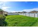 Well-maintained backyard boasts lush green grass and a pristine white fence, ideal for outdoor enjoyment at 147 Seville Dr, Davenport, FL 33837