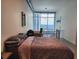 Bedroom featuring a full bed, desk, and large windows with city views; lofted area beyond railing at 150 E Robinson St # 419, Orlando, FL 32801