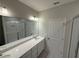 Bright bathroom featuring a double vanity with sleek white countertops and a glass-enclosed shower at 15316 Burgtheater Dr, Winter Garden, FL 34787