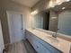 Bathroom featuring double vanity, granite countertop, large mirror, and neutral decor at 15316 Burgtheater Dr, Winter Garden, FL 34787
