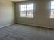 Bright bedroom featuring neutral walls, plush carpet, and two windows offering neighborhood views at 15316 Burgtheater Dr, Winter Garden, FL 34787