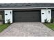 Two-car garage with a brick driveway, offering ample space for vehicles and storage at 15316 Burgtheater Dr, Winter Garden, FL 34787