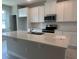 Bright kitchen featuring white cabinets, stainless steel appliances, a large island with sink, and tile backsplash at 15316 Burgtheater Dr, Winter Garden, FL 34787