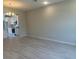 Open-concept living space with wood-look tile floors, recessed lighting, and views of the modern kitchen at 15316 Burgtheater Dr, Winter Garden, FL 34787
