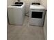 Bright laundry room featuring a new washer and dryer set on tile flooring at 1727 Buckeye Rd, Davenport, FL 33837