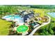 Community aerial view of pool, splash pad, clubhouse, playground, and green spaces in a Primary planned neighborhood at 17416 Painted Leaf Way, Clermont, FL 34714