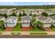 Aerial view of a neighborhood featuring well-maintained homes with green lawns and palm trees at 17416 Painted Leaf Way, Clermont, FL 34714