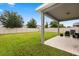 A spacious backyard featuring a covered patio with outdoor seating and well-maintained lawn at 17416 Painted Leaf Way, Clermont, FL 34714