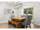 Bright dining area with a modern light fixture, wooden table, bench seating, and sliding door to the backyard at 17416 Painted Leaf Way, Clermont, FL 34714