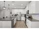 Modern kitchen featuring stainless steel appliances, gray countertops, white cabinetry, and stylish pendant lighting at 17416 Painted Leaf Way, Clermont, FL 34714