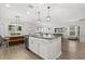 Open-concept living room with a kitchen island, dining area, and view into the sitting room featuring natural light at 17416 Painted Leaf Way, Clermont, FL 34714