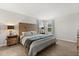 Serene bedroom featuring a wood accent headboard, side tables, and abundant natural light from the windows at 17416 Painted Leaf Way, Clermont, FL 34714