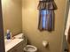 Modest bathroom features a sink, toilet, and a window with a curtain for privacy at 1812 Firwood Ct, Orlando, FL 32818